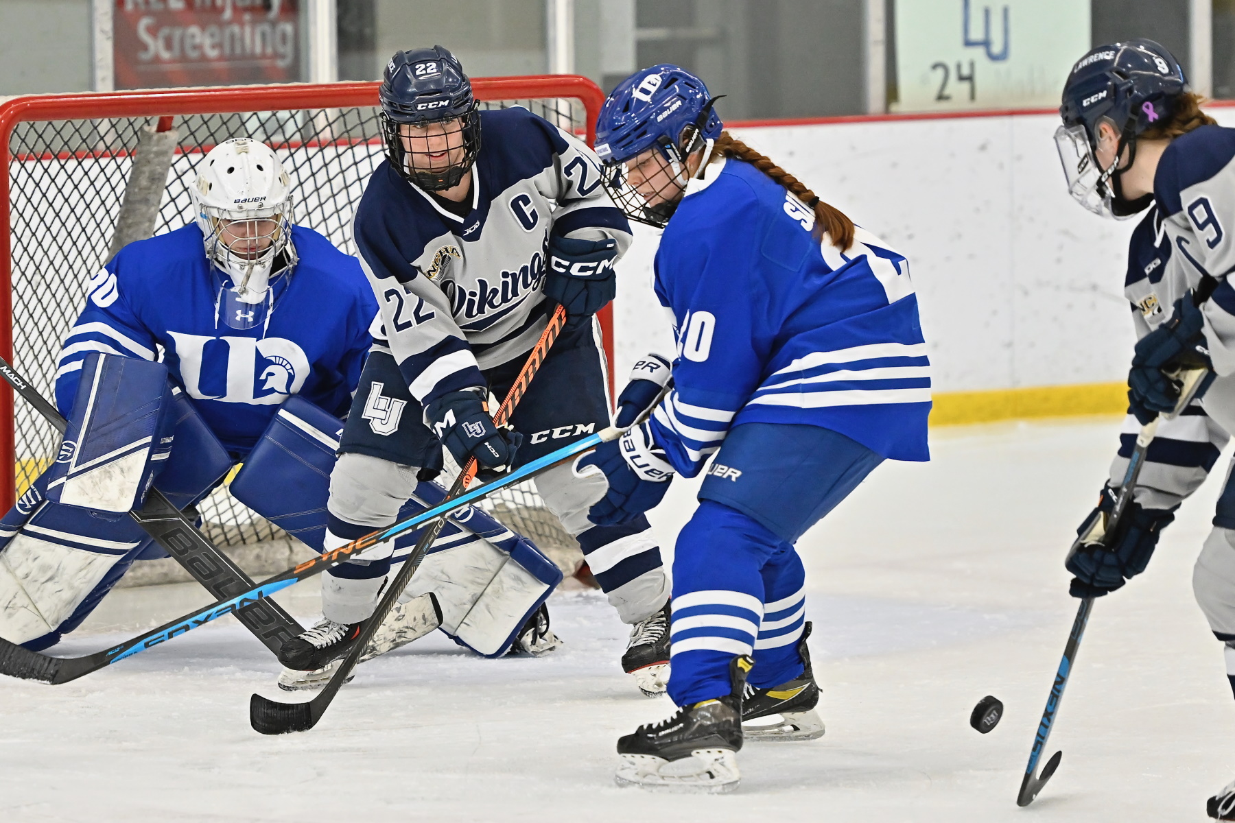 Seniors Lauren Askenazy (22) and Delaney Kingsland (9) compete for the puck against the University of Dubuque.