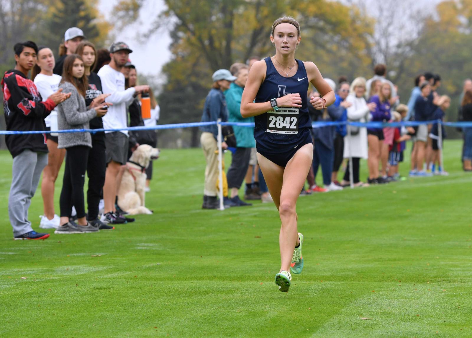 Cristyn Oliver crosses the finish line to the win the Midwest Conference Tournament.