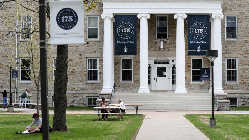 Students chat on the green in front of Main Hall, which is adorned with 175th anniversary banners.