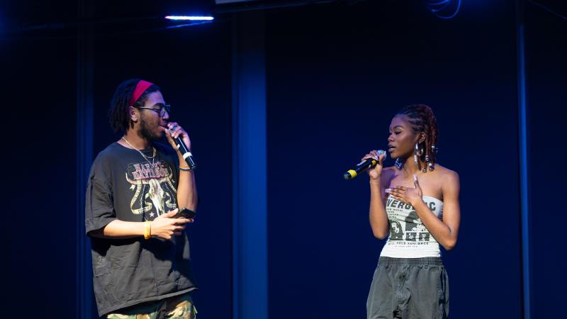 Two students sing a song on stage.