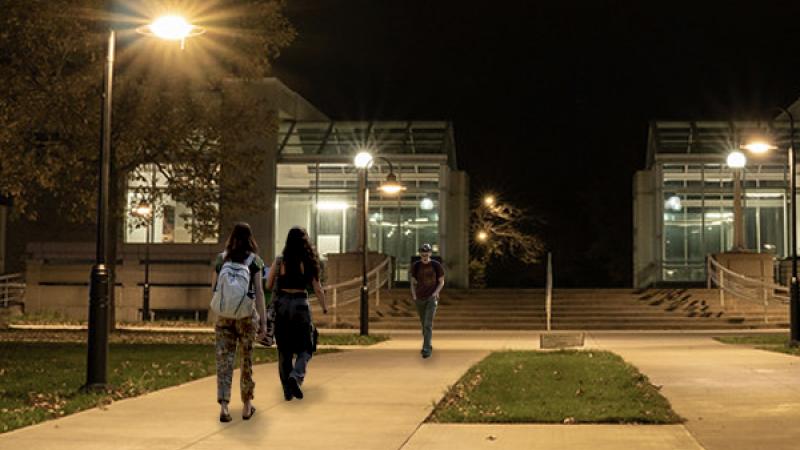 Students walking in front of Conservatory at night