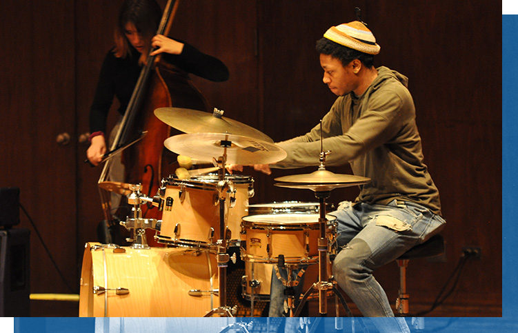 A student plays the drums.