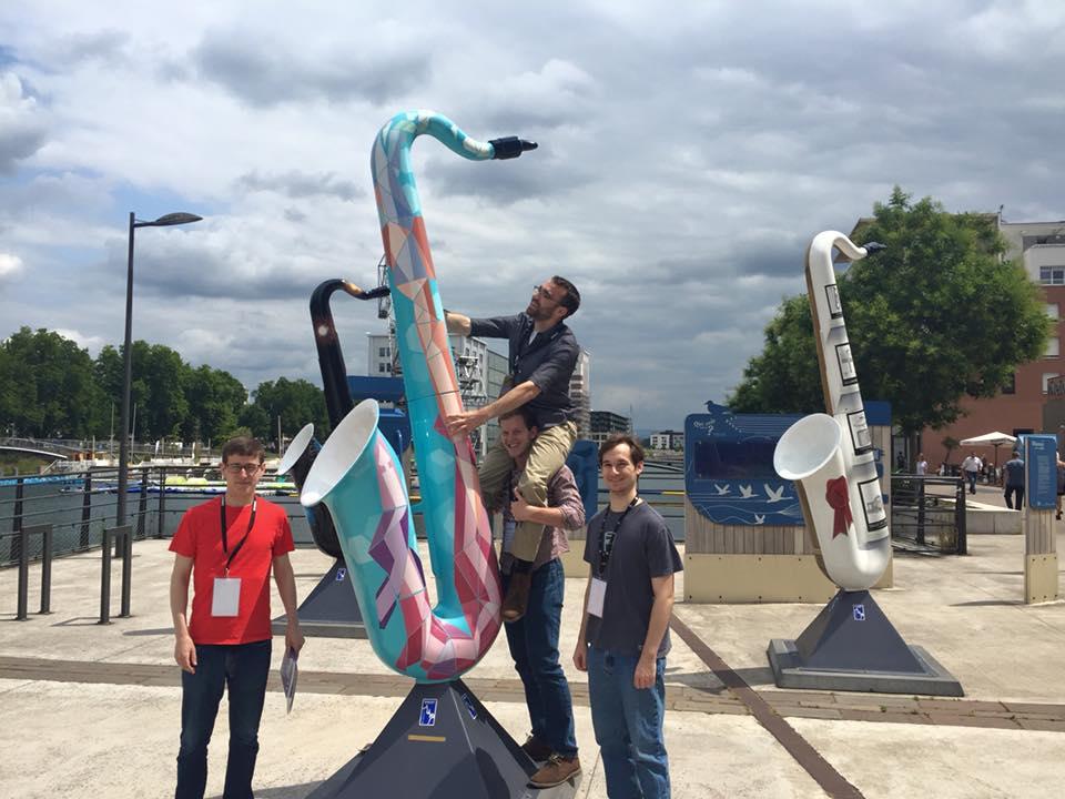Students posing with a giant saxophone