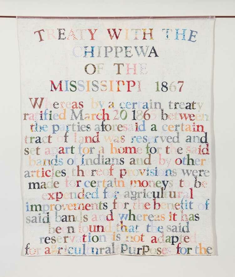 Colorful fabric letters that say Treaty with the Chippewa against a white quilted background