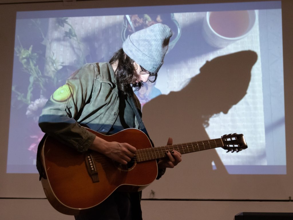 Student playing a guitar.