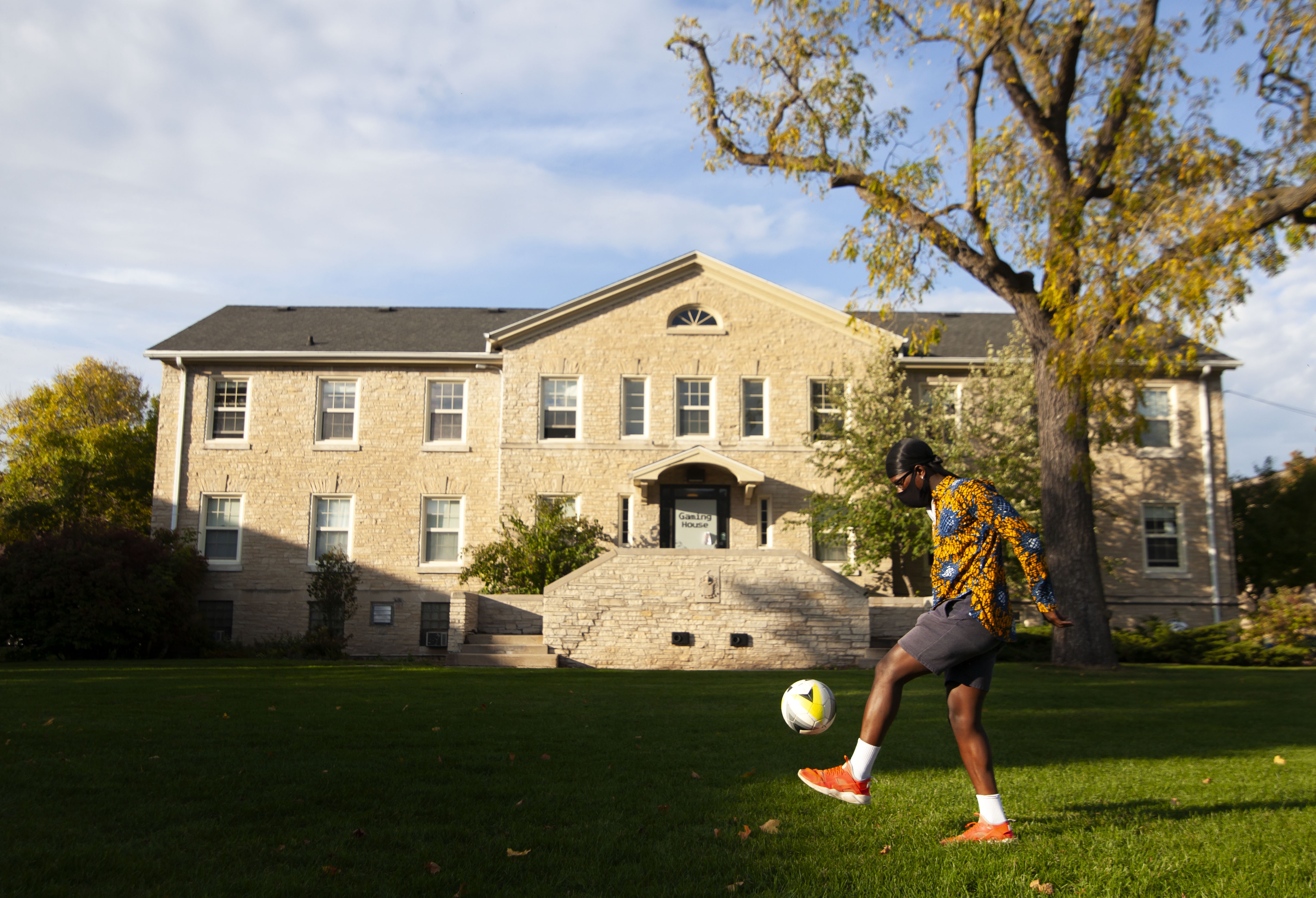 Nicholas Jatta '21 kicks kicks around a soccer ball on the Quad with friends