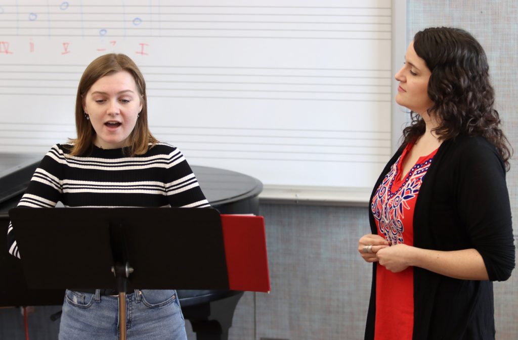 Esteli Gomez listens intently as Mae Capaldi sings during a studio class.