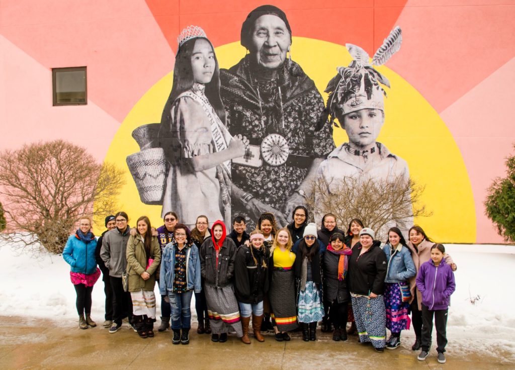 LUNA members next to the the mural on the side of the Buchanan Kiewit Wellness Center.