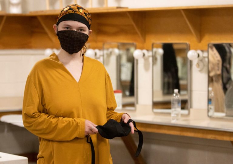 Lilly Kuipers ’23 holds a finished woodwind mask in the costume shop.