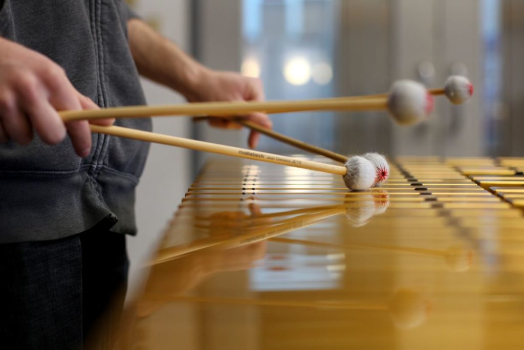 close up of the hands of a student playing the xylophone 