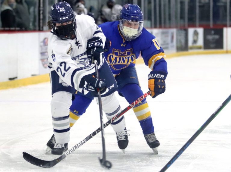 Lauren Askenazy jostles with a Saints player for the puck.