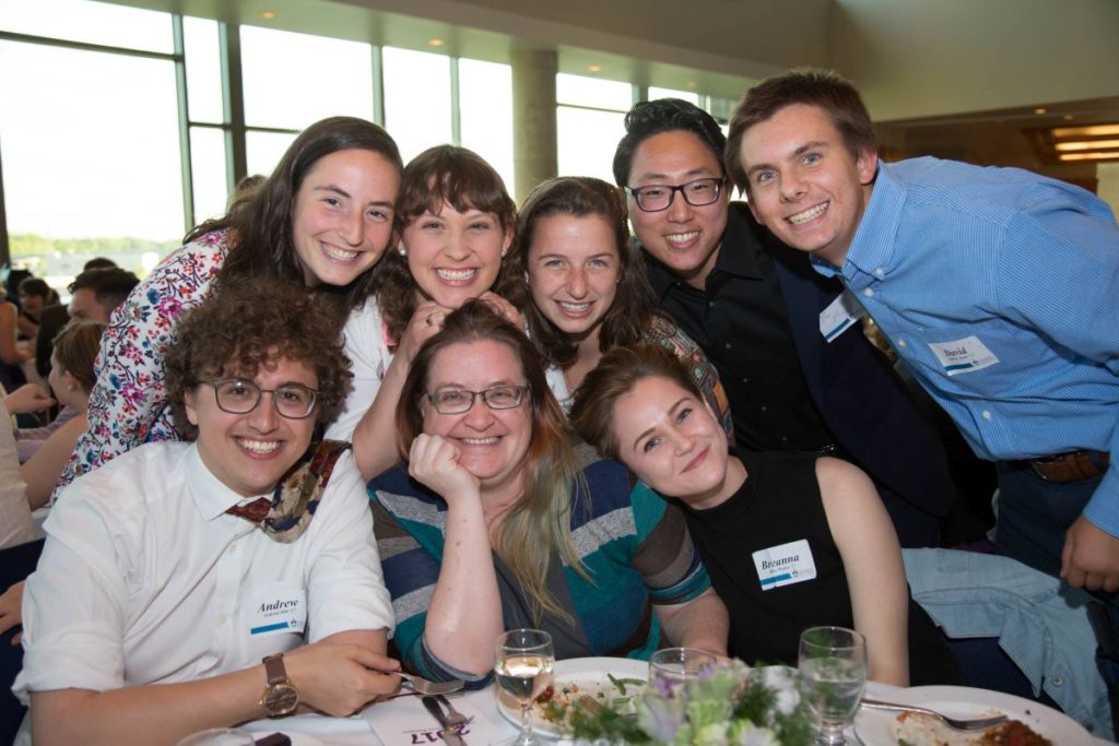 seven students and their professor get together to take a picture 