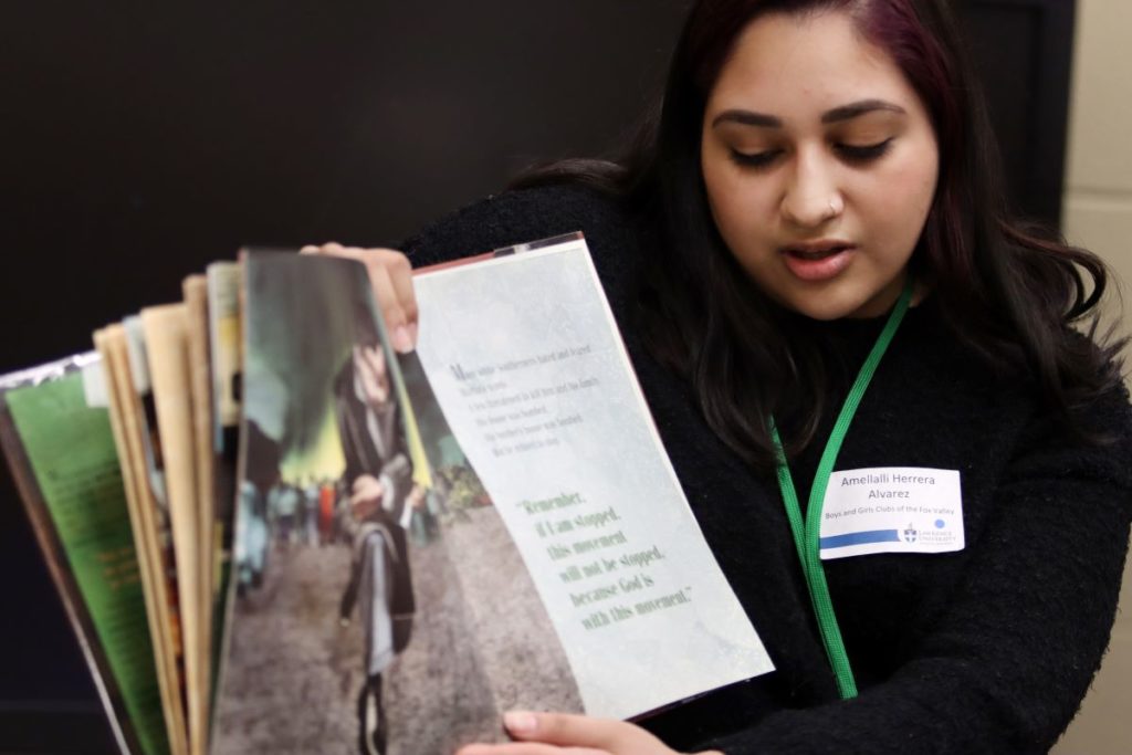 Lawrence student reading a book to kids 