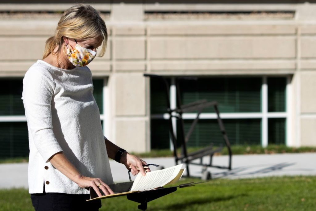 Professor Darling reading music in the green area outside the Conservatory 