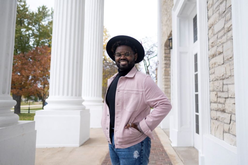 Professor Holiday posing outside Main Hall 