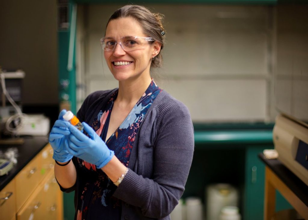 Professor Fleshman wearing goggles and gloves in a lab 