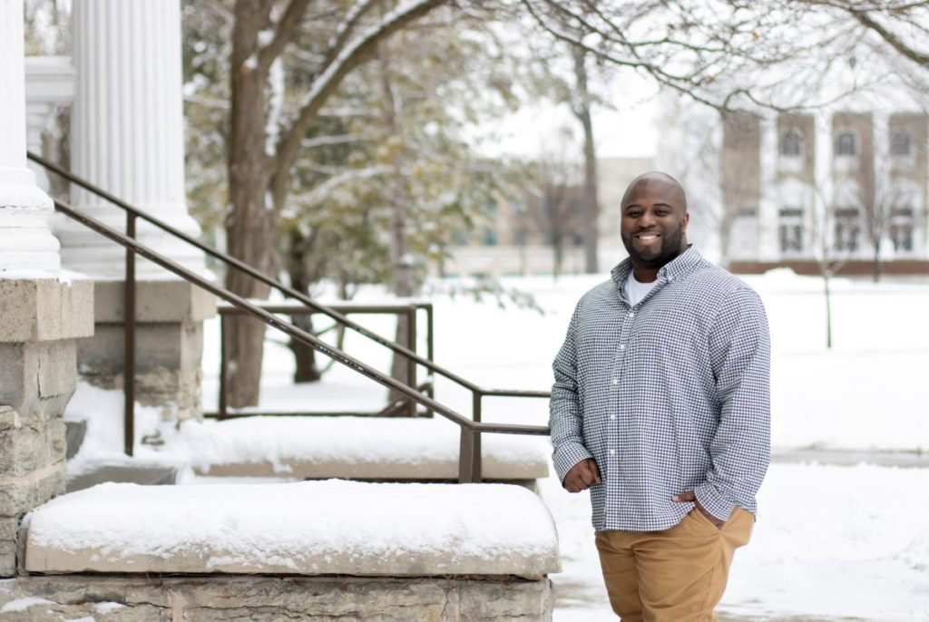 Professor Smith posing outside Main Hall on a snowy day