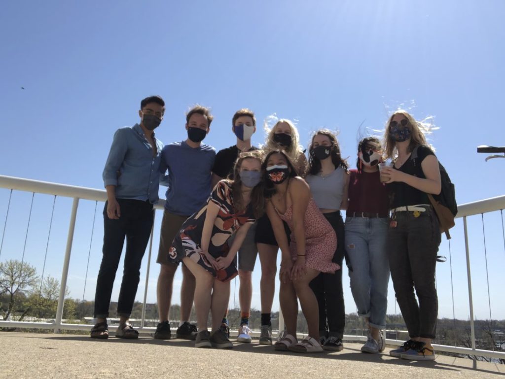 group of nine students take picture on a sunny day outside Briggs Hall