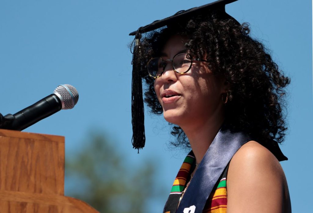 Jailene Rodriguez, behind the podium, addressing her classmates during commencement 