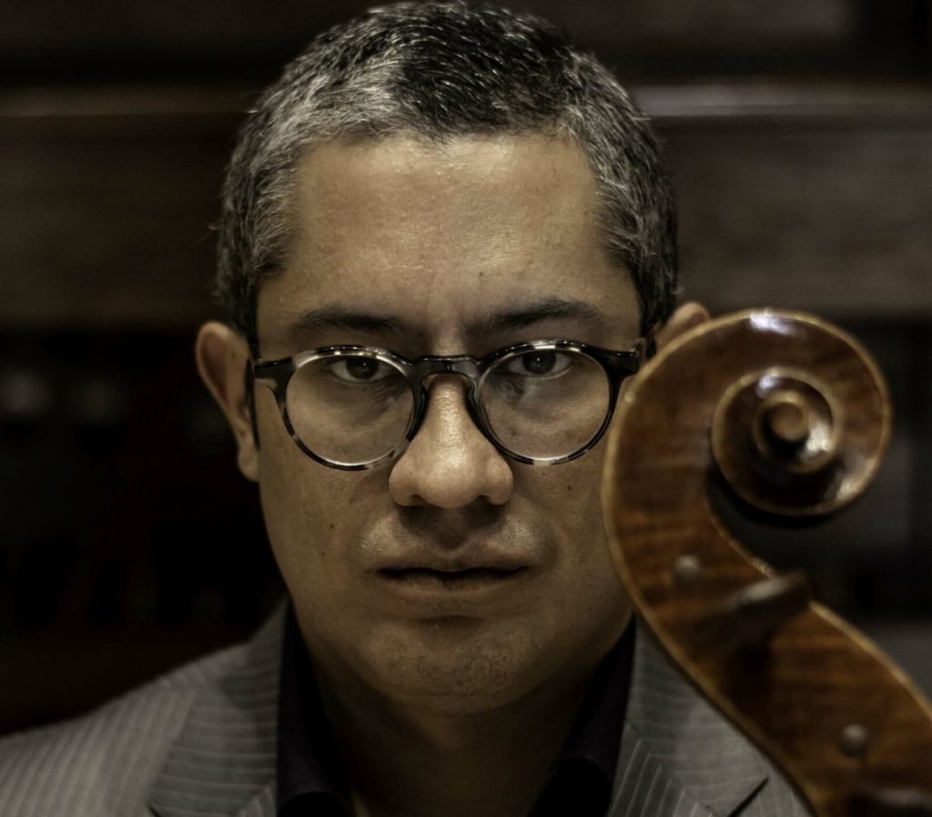Close up of Professor Contreras' face behind the scroll of the cello