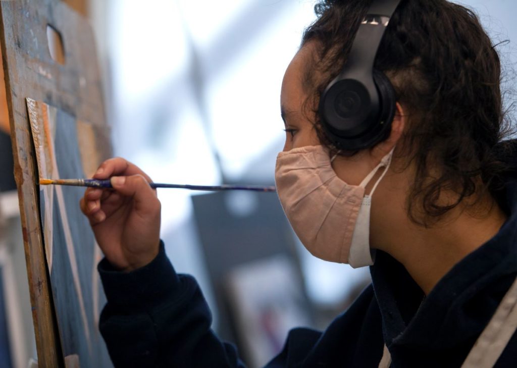 Side profile of Jailene Rodriguez while she paints 