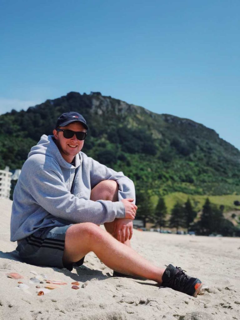 Ryan Leonard ’19 poses for a photo in Tauranga in front of Mount Maunganui.