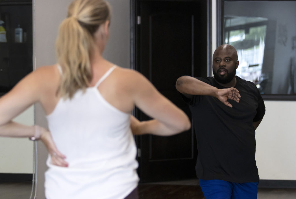 Jesus Smith practicing while the choreographer looks at him 