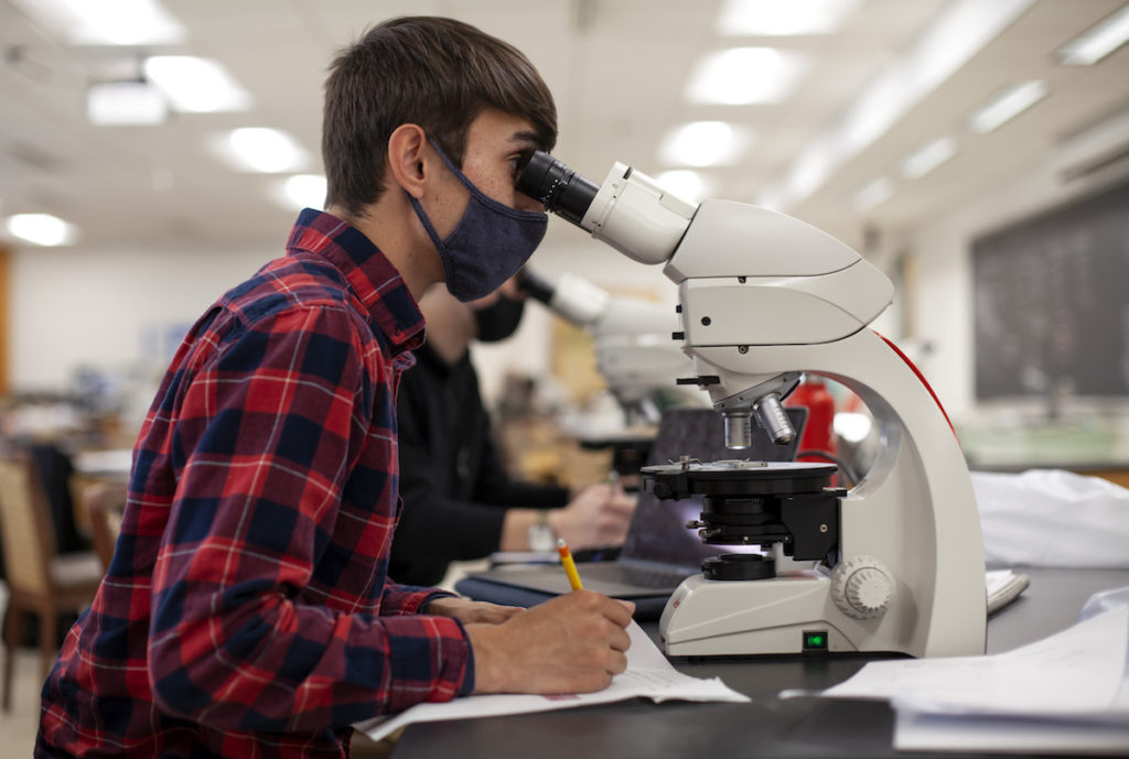 Student using a microscope in a laboratory  