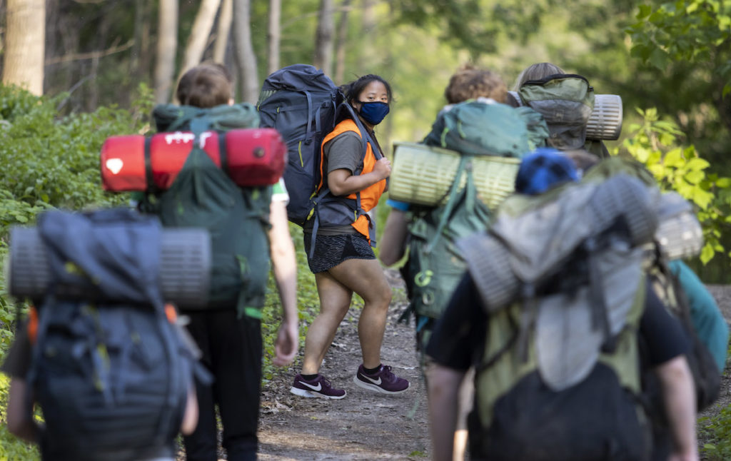 Students hiking with backpacks and camping gear 