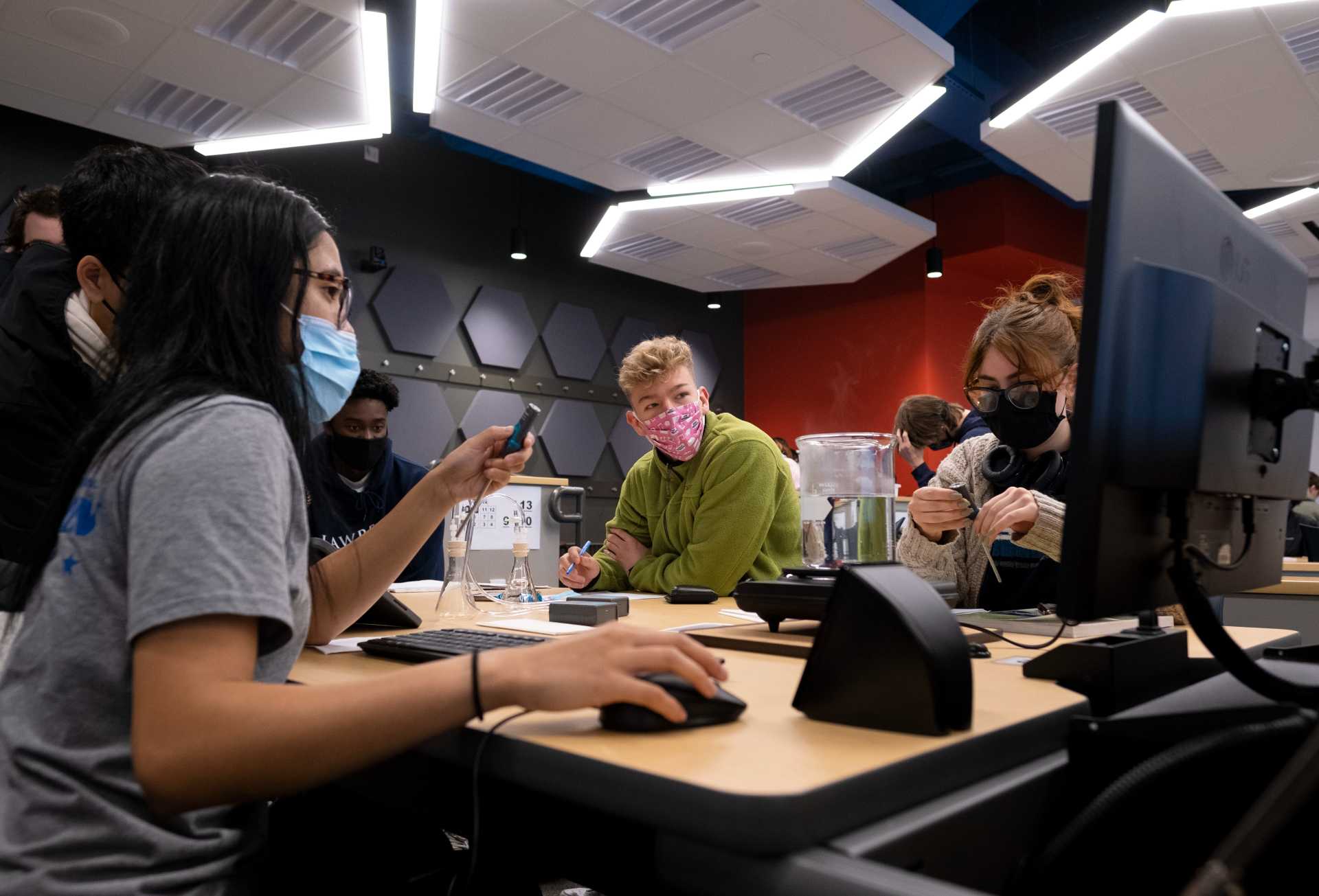 Nicole Legman, a sophomore, Ryan Johnson, a senior, and Haleigh Andrews, a first-year, working off the computer around a table during Introduction to Physic