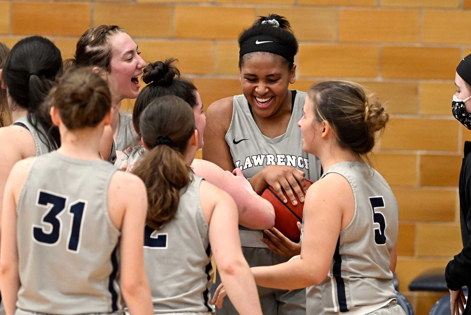 Kenya Earl holds the basketball while she celebrates with her teammates after setting the scoring record.