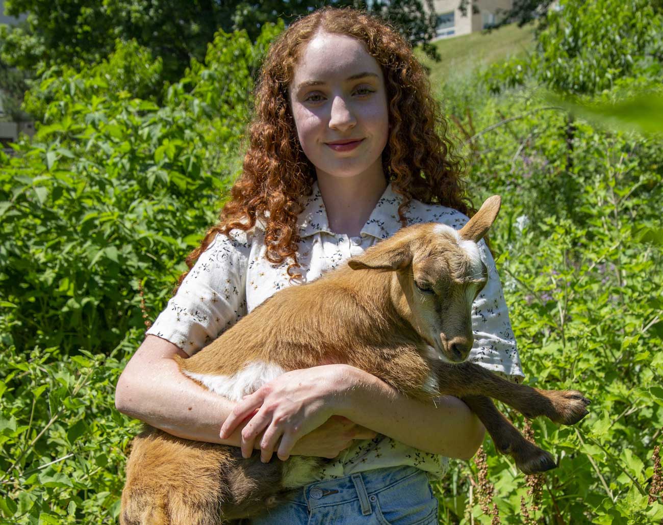 Student holding a goat