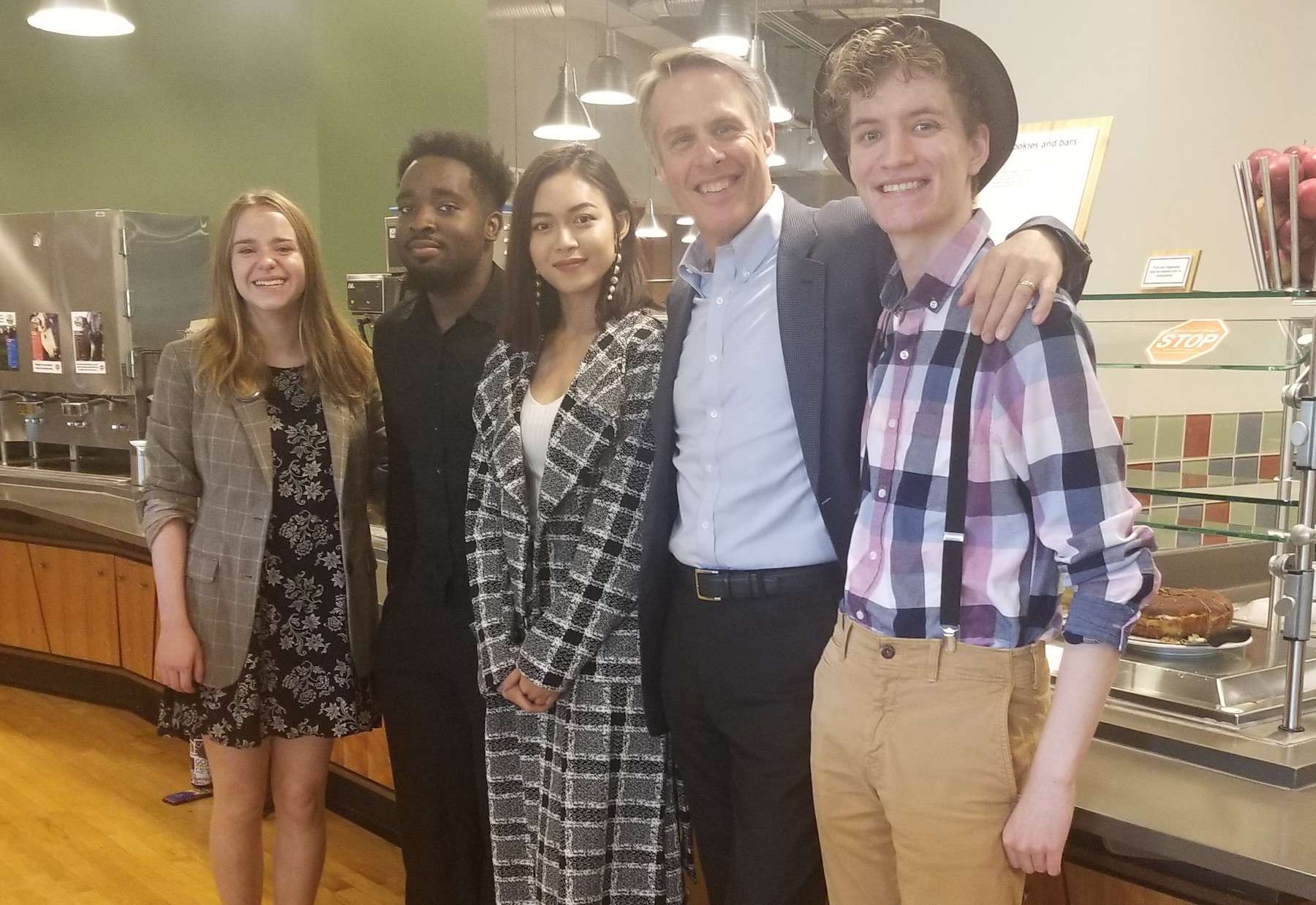 Terry Moran poses with four Lawrence students inside Andrew Commons.