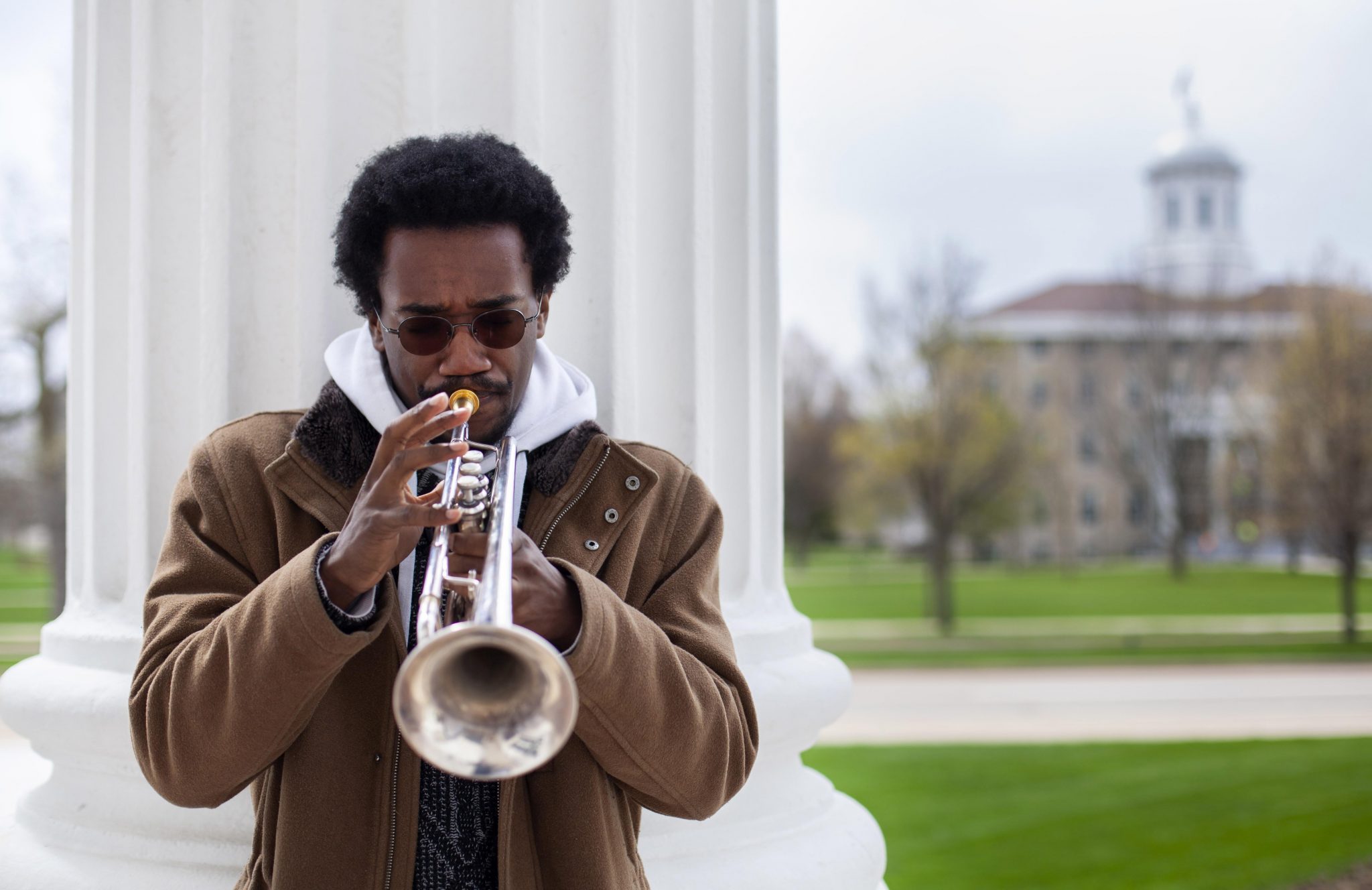 Earl Simons plays trumpet next to column of Memorial Chapel.