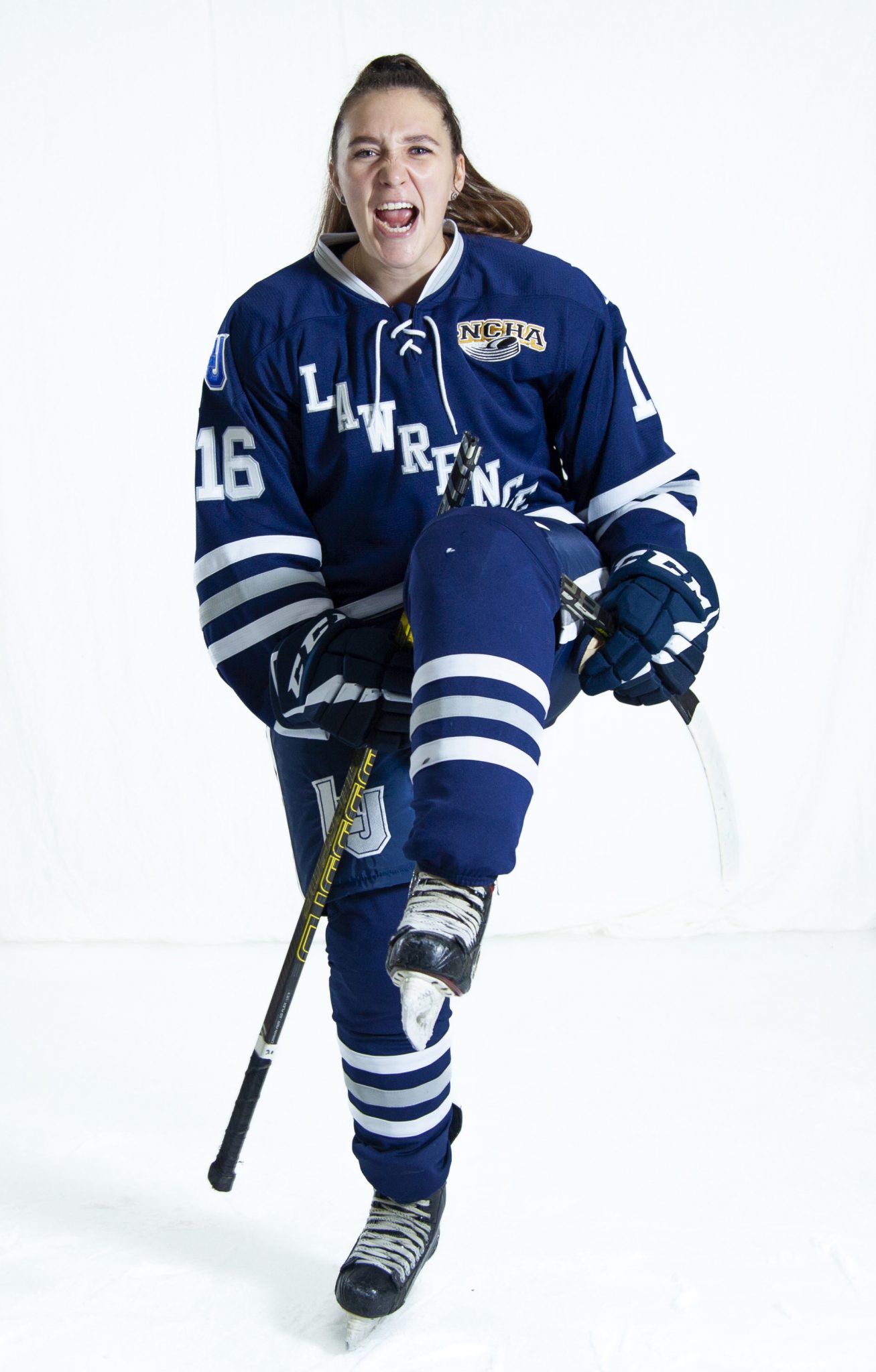 Maggie Macneil poses with one leg lifted in her hockey uniform.