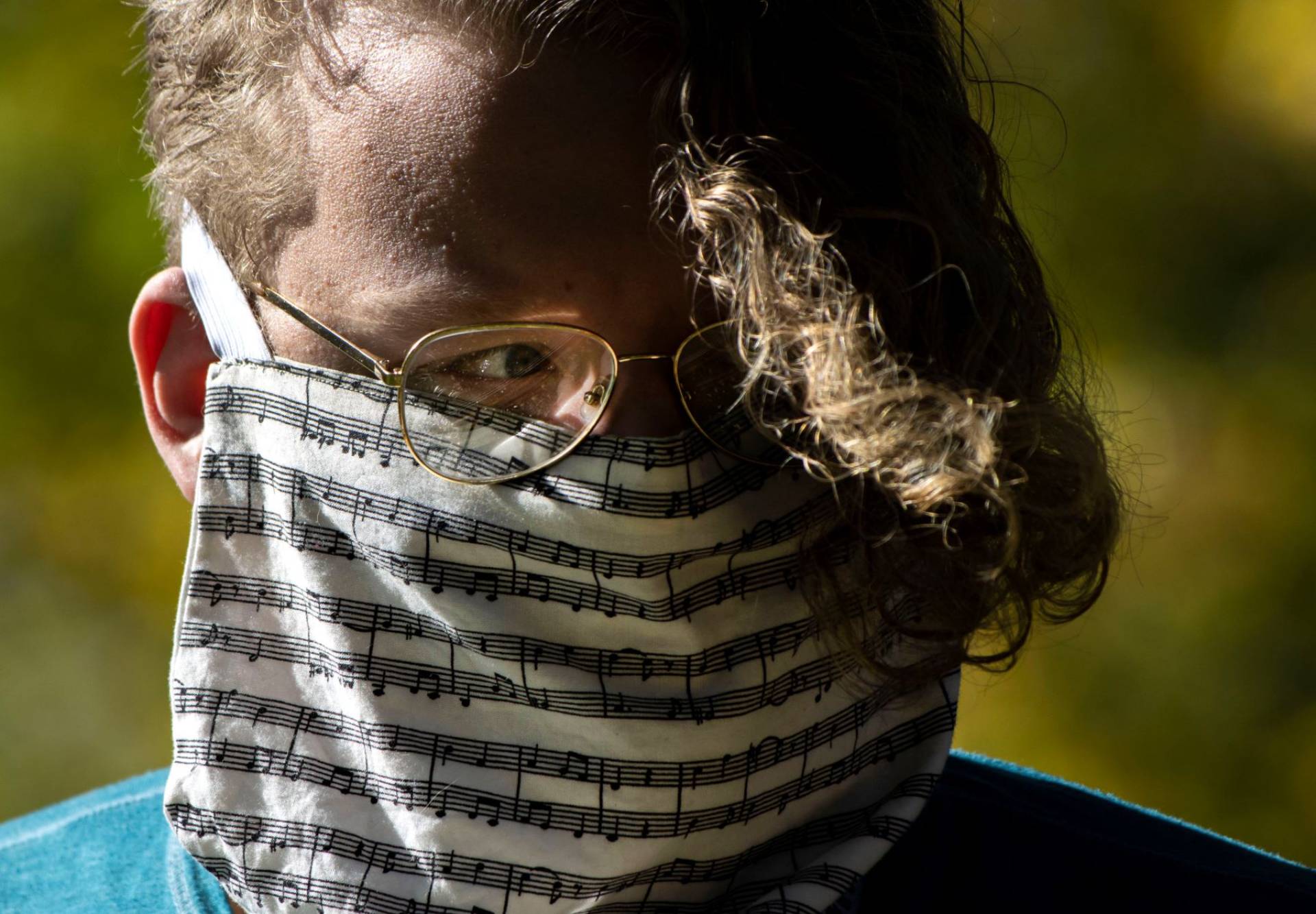 Student in homemade cloth mask with sheet music pattern.