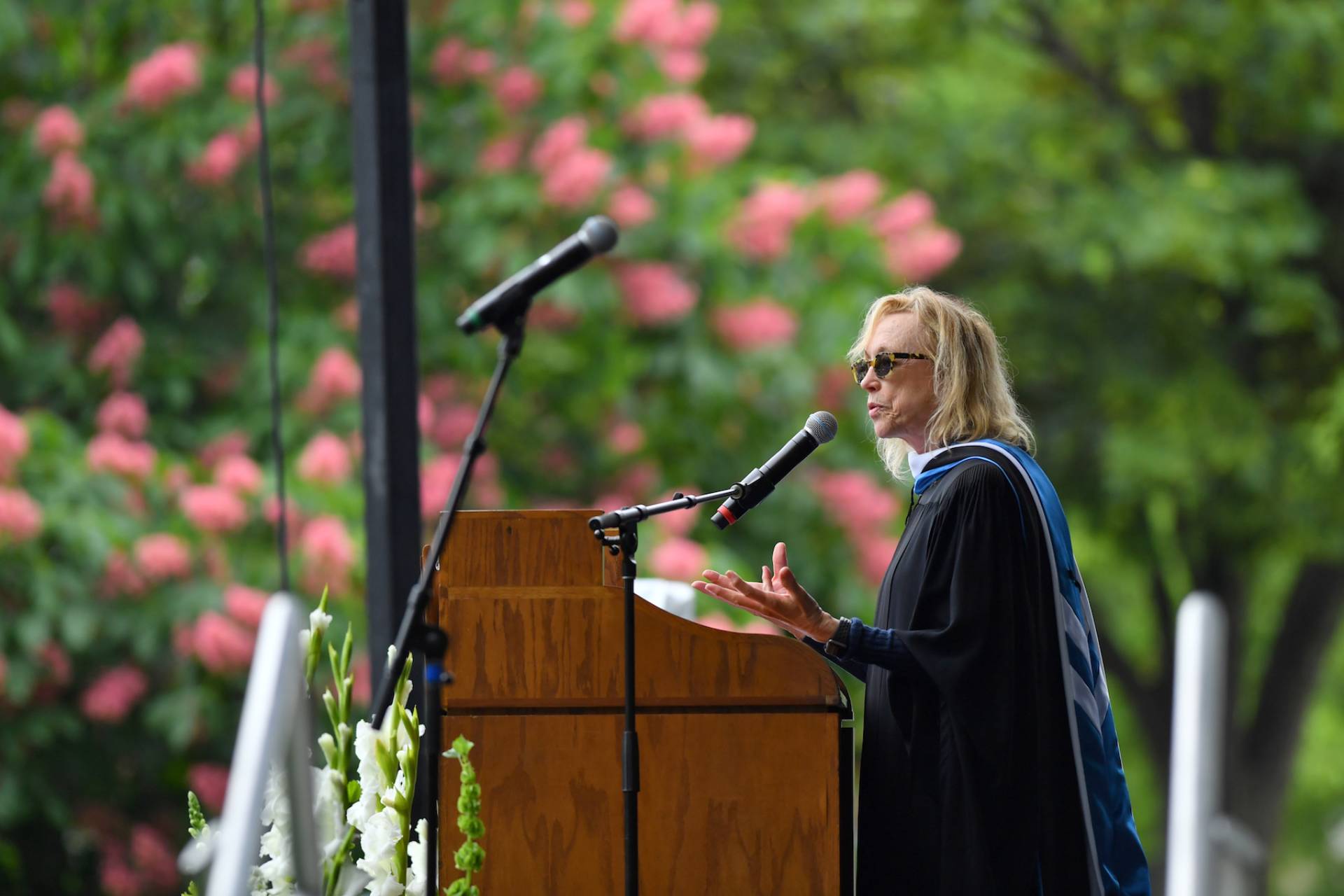 Lee Shallat Chemel speaks into microphone behind lectern.