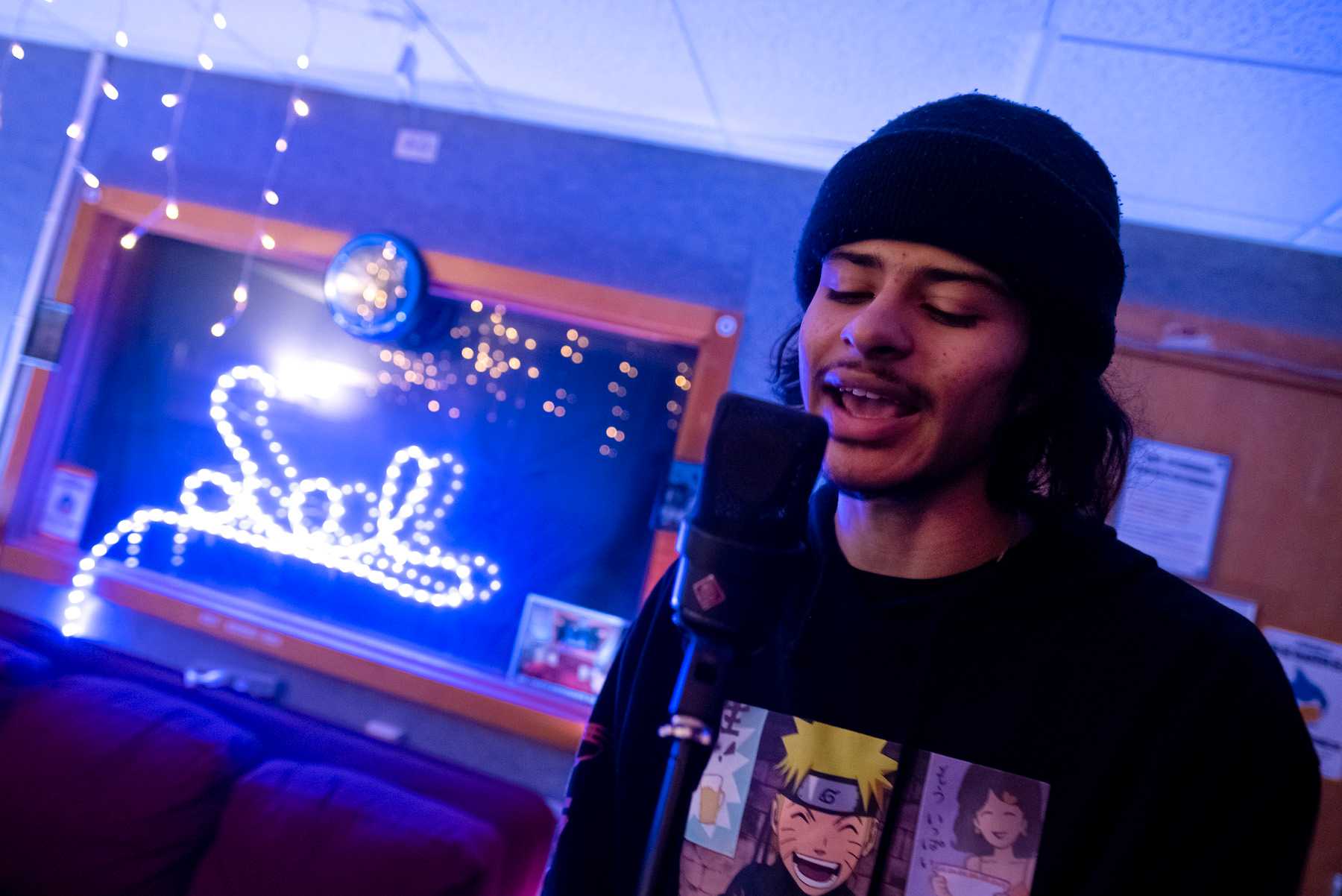 Xavier Yon sings into a microphone as he practices with VOODIS bandmates in SOL Studios.