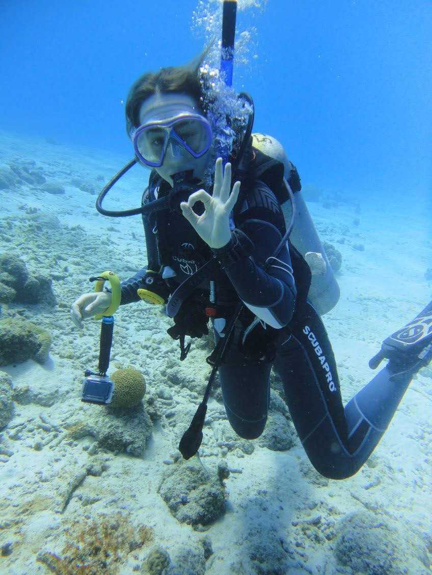 Eleanor Meng, dressed in scuba gear, gives the OK sign as she dives near Bonaire.