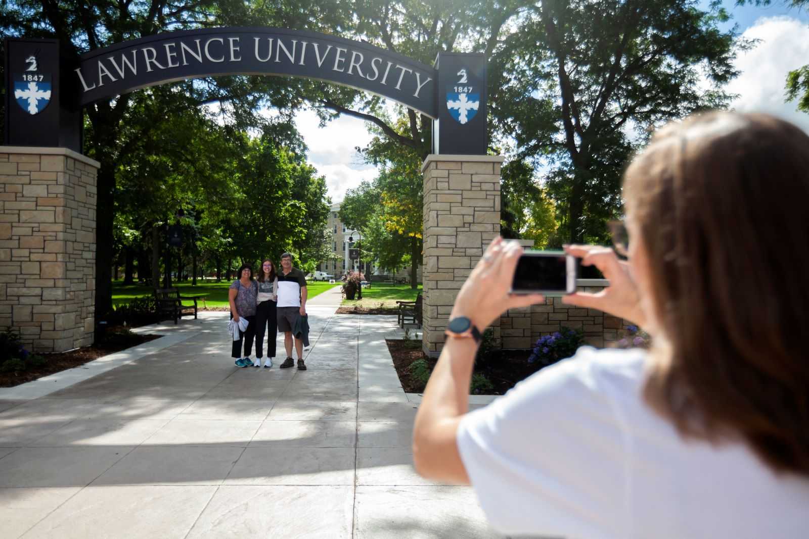 Savannah Betterley, a first-year student, stands with her parents, Regina Paradis and Gene Betterley, as they get a photo taken under the Welcome Arch. 