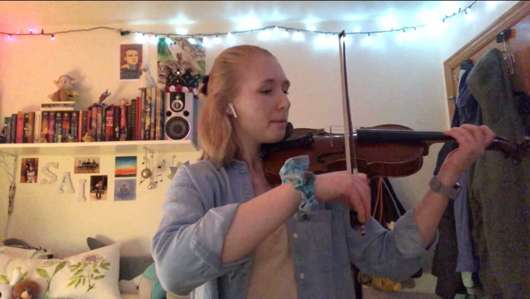 Mindara Krueger-Olsen plays the violin as she records her part of the remote recording.
