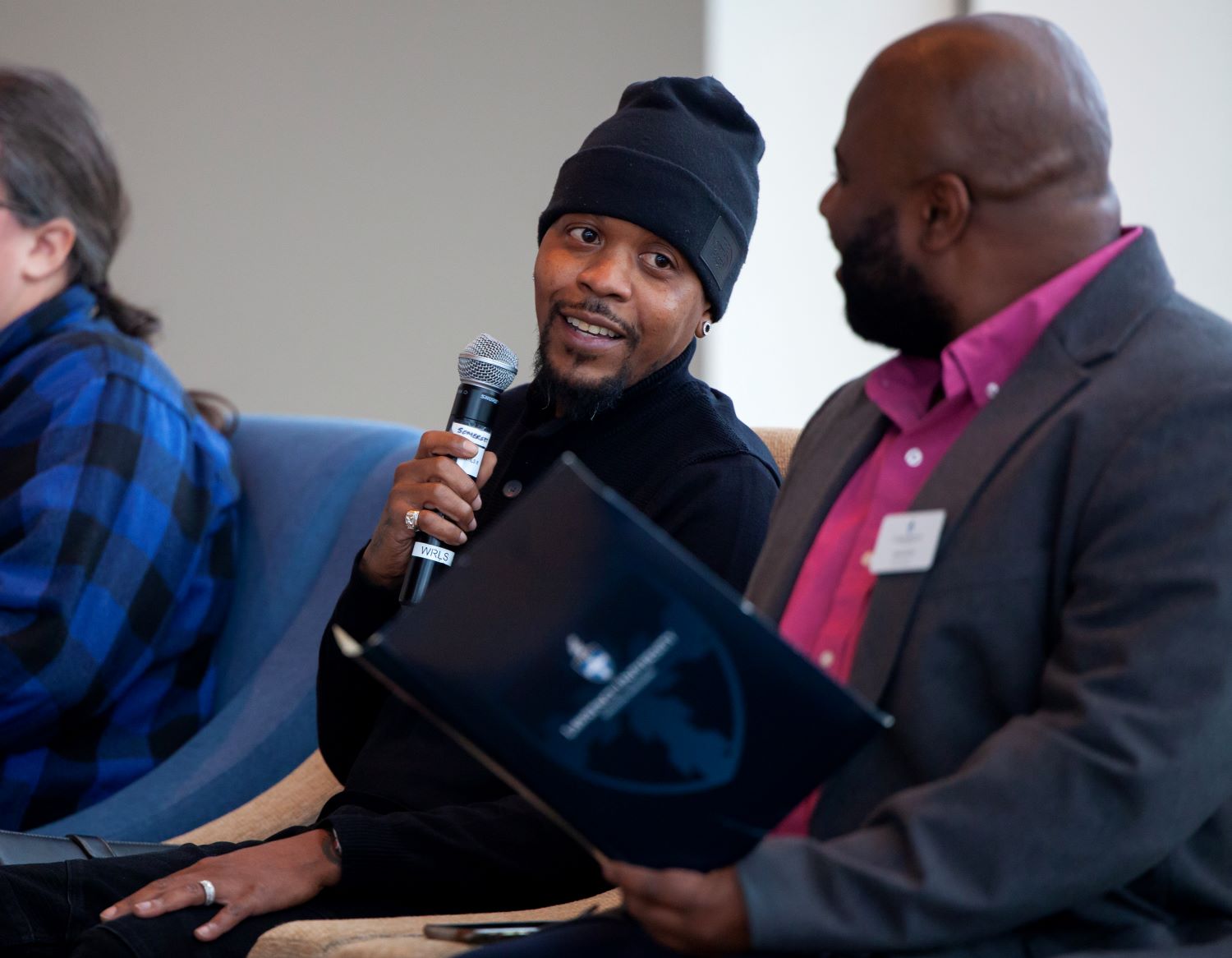 Cainan Davenport, co-owner of Taperz Barber Shop, speaks during the Transformational Leaders of Color Breakfast: There is No Gain without Struggle, held in Warch Campus Center as part of the MLK Day celebration. Jesus Smith looks on.