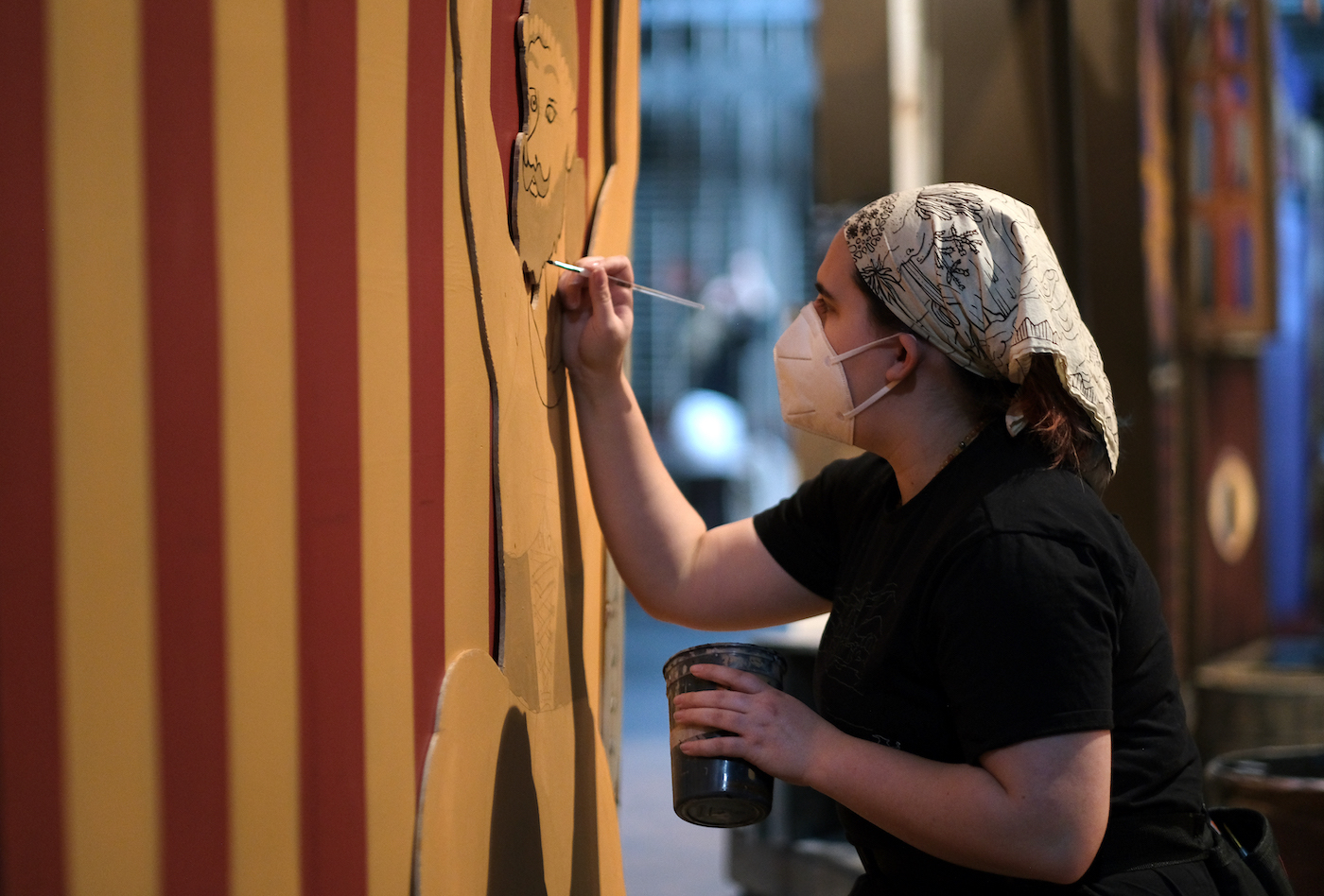 Sophomore August Hendrix paints details on one of the cutouts on the Stansbury stage. 