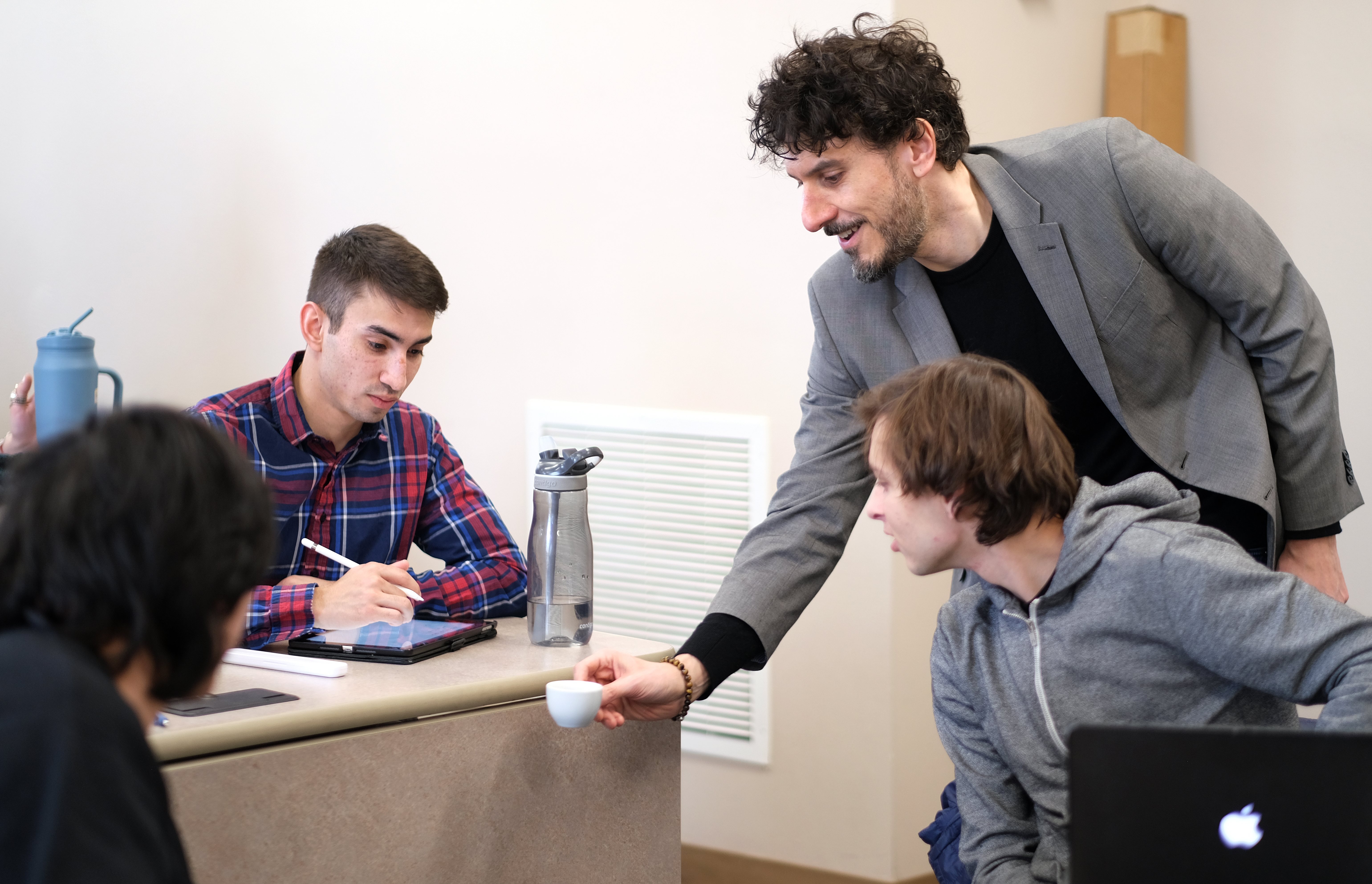 Greg Milano talks coffee and shows students a cup of espresso during a class session.