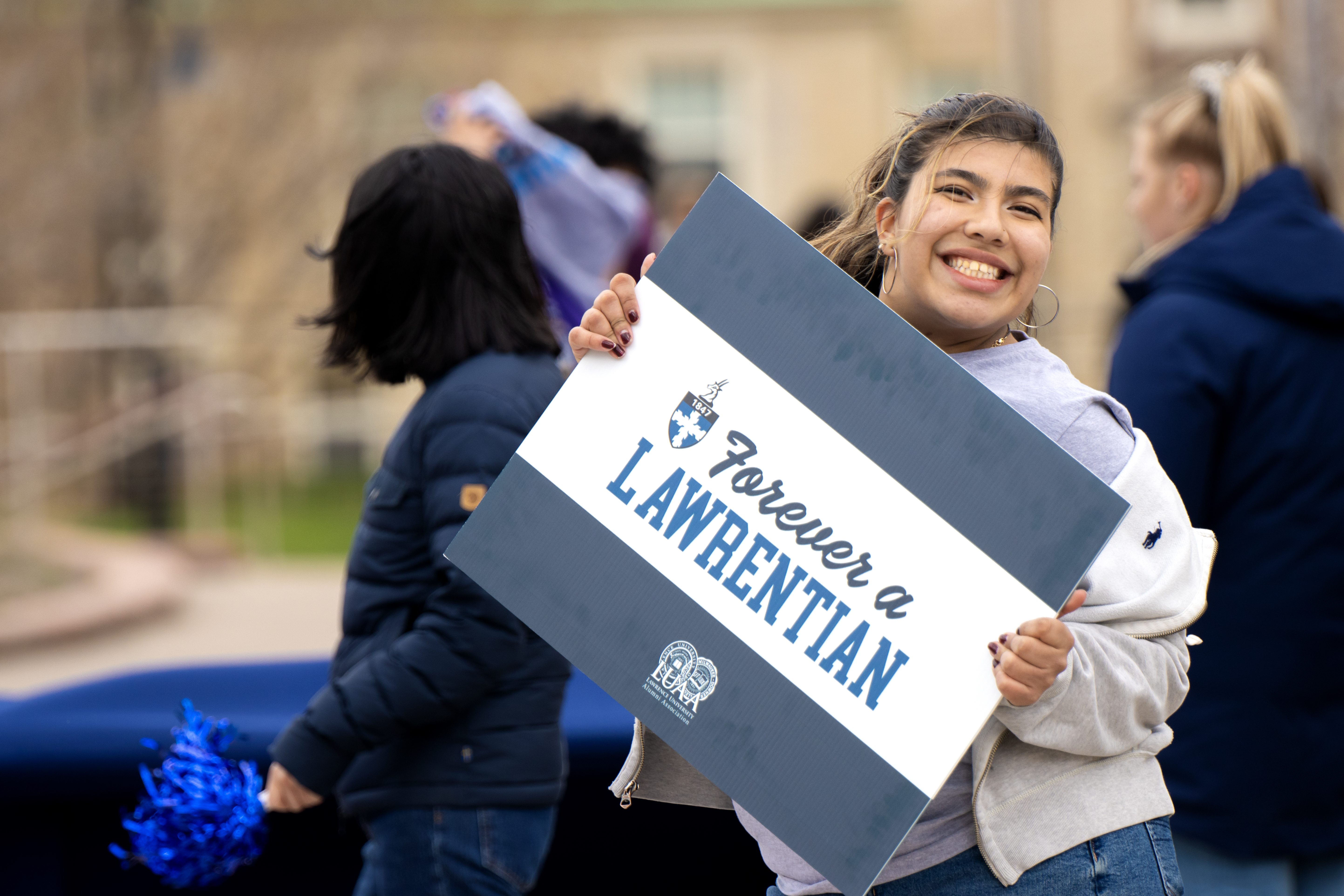 Sophomore Bruna Velez holds a Forever a Lawrentian sign as games are held on campus to win prizes. 