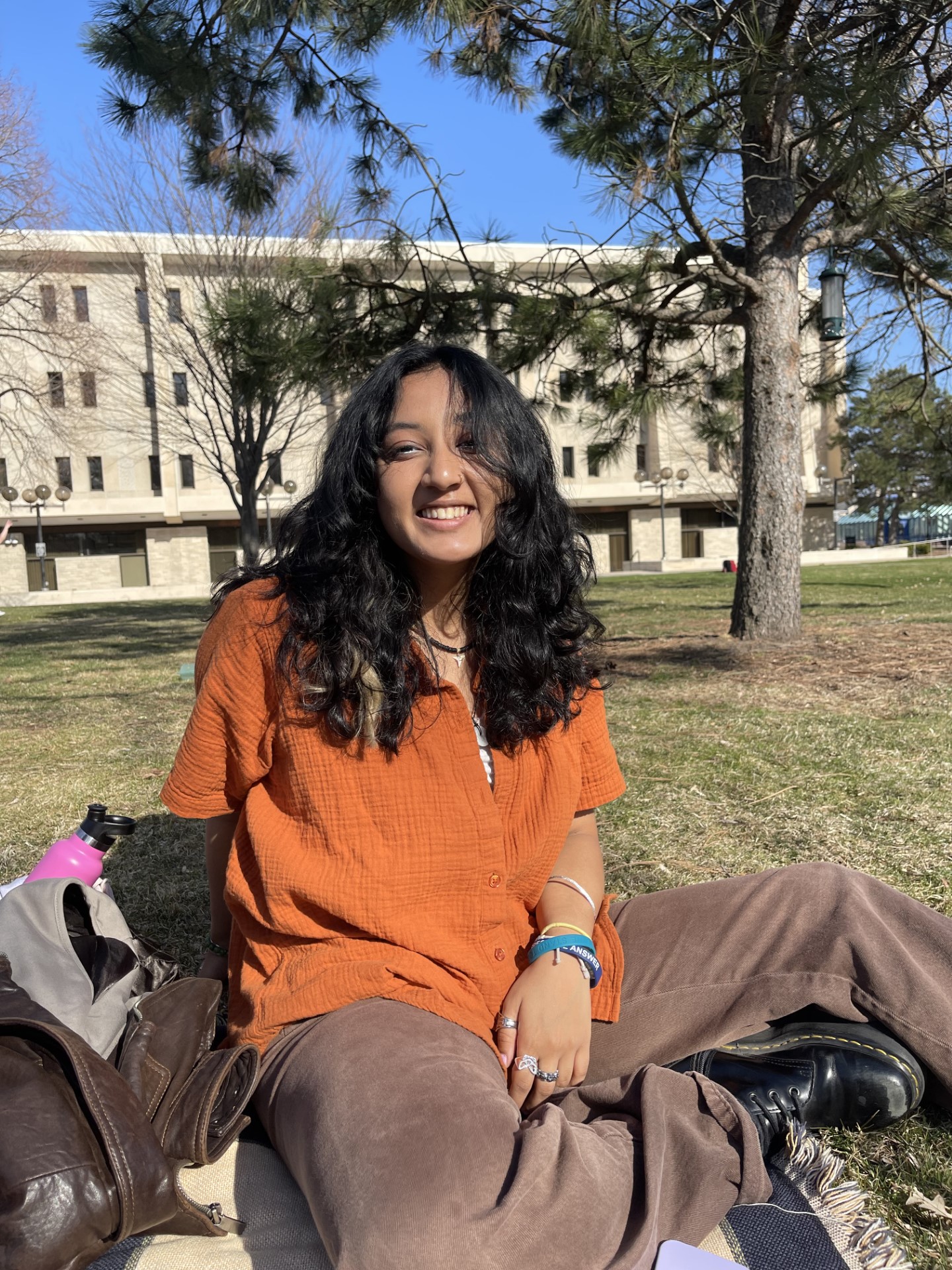 Tee Karki '23 sits on the lawn on campus.