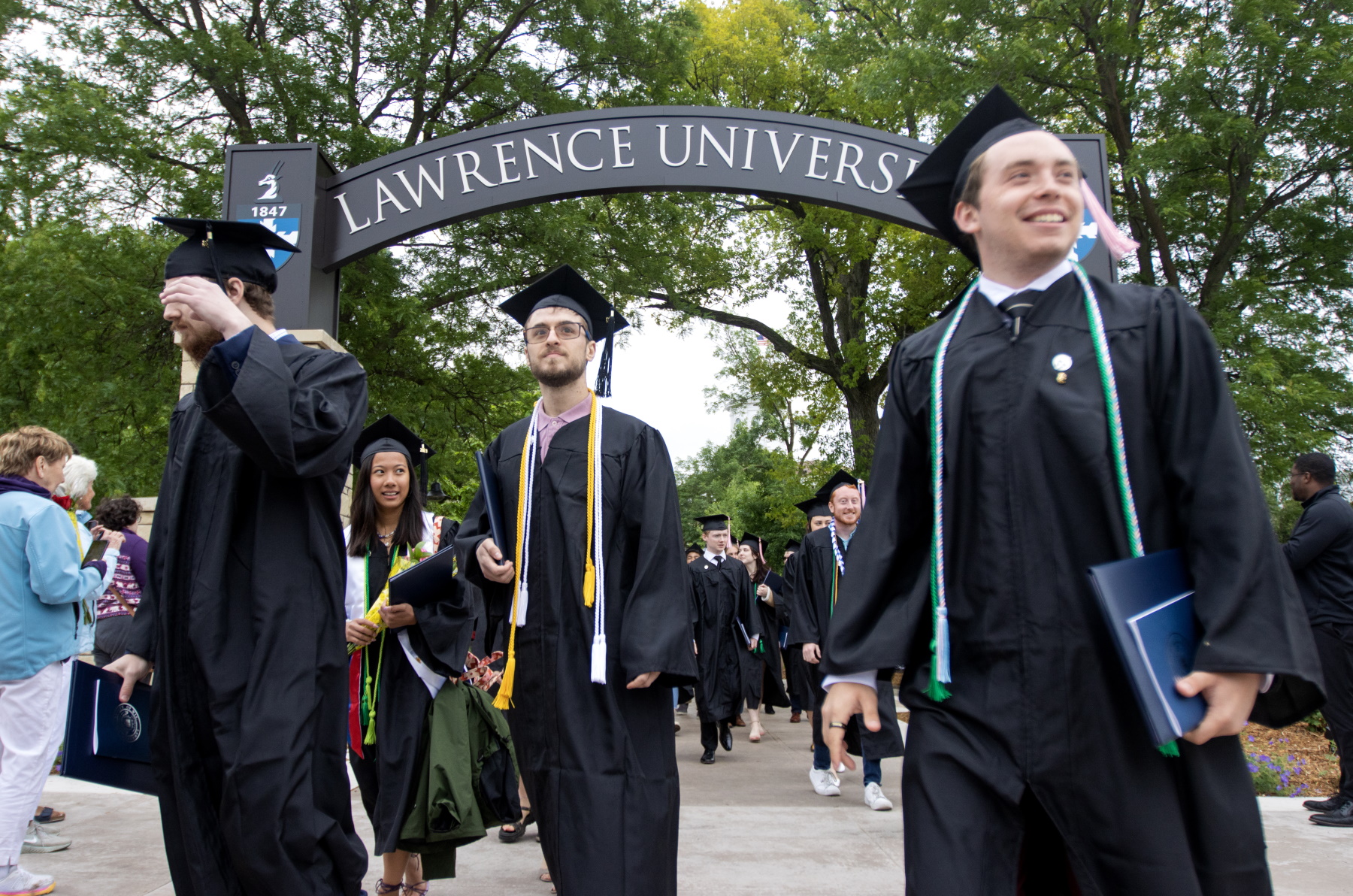 Graduates walk through the Lawrence Arch at the close of Commencement.