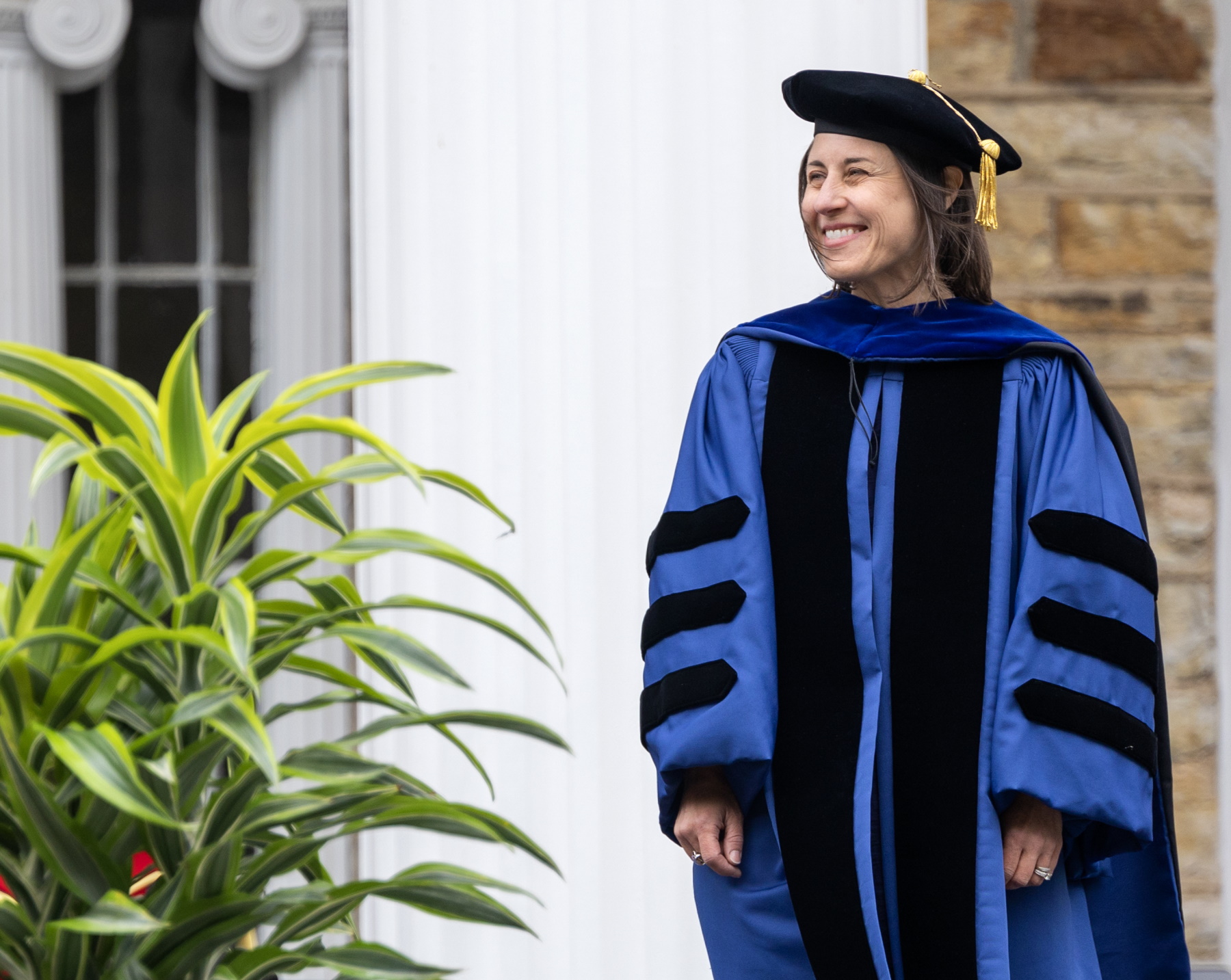 Lori Hilt stands on the Commencement stage as she receives her award.