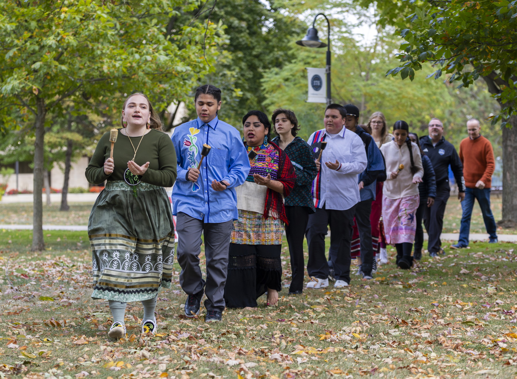 Participants walk through Main Hall Green as part of the Indigenous Peoples' Day Celebration.