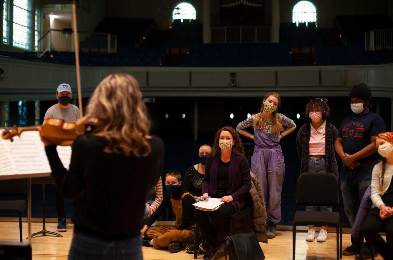 Students and professor listen while Madeline Markhem, a first-year, performs during violin studio.